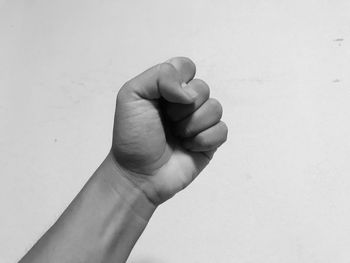 Cropped image of person fist against gray background