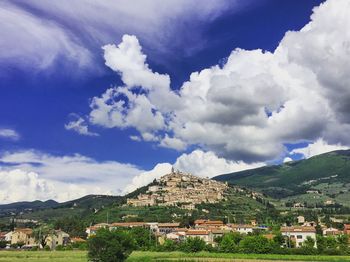 Buildings in city against cloudy sky