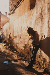 Side view of woman on wall in city