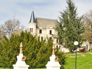 View of trees and building against sky