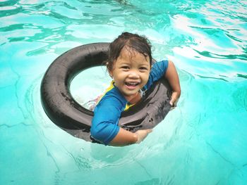 Portrait of happy girl playing in swimming pool