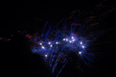 Firework display against sky at night