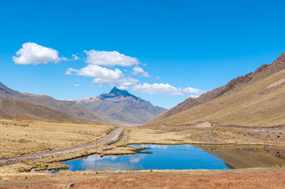 Scenic view of lake and mountains against blue sky