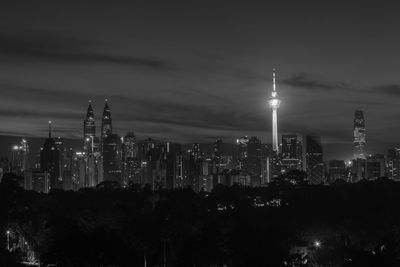 Illuminated buildings in city against sky at night