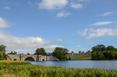 Arch bridge over river against sky