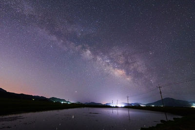 Scenic view of lake against sky at night