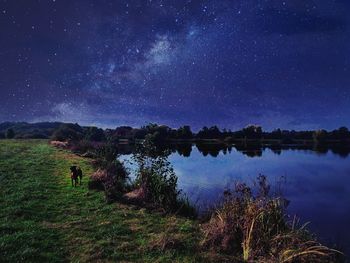 Scenic view of lake against sky at night