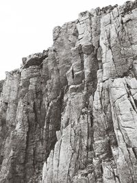 Low angle view of cliff against clear sky