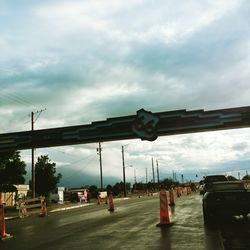 Cars on road in city against sky