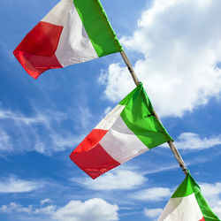 Low angle view of flags waving against sky