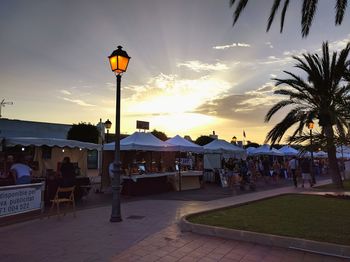 People at restaurant against sky during sunset