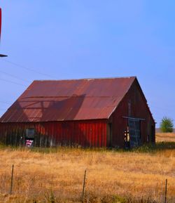 Abandoned house on field against clear sky