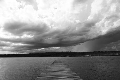 Pier over lake against sky