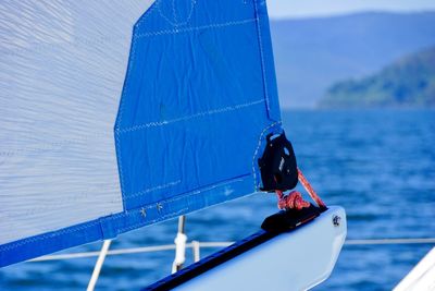 Close-up of boat sailing on sea against sky