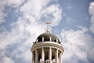 Low angle view of bell tower by building against sky