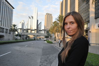 Side view portrait of woman standing on street in city