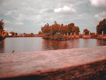 Scenic view of river by trees against sky