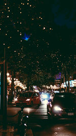 Cars on illuminated street at night