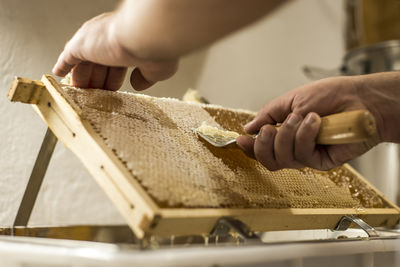 Man removing wax from honeycomb