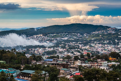 Downtown city view with dramatic cloudy sky at evening from mountain top