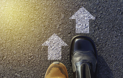 Low section of person standing on road