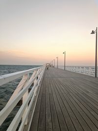 Pier over sea against sky during sunset