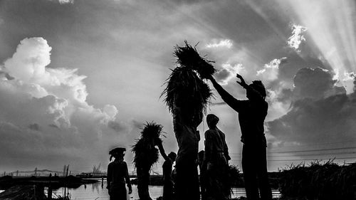 Silhouette people against sky