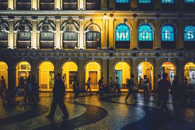 People in illuminated building at night