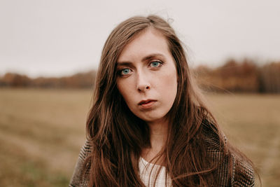 Sad girl with blue eyes. portrait of a girl in brown tones. walk through the woods. autumn colors. 