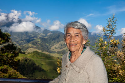 Senior woman tourist looking at the  landscapes of the central ranges in colombia. travel concept