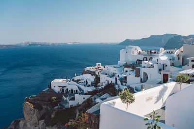 High angle view of townscape by sea against clear sky