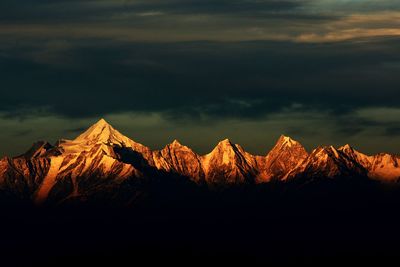 Scenic view of snowcapped mountains against sky during sunset