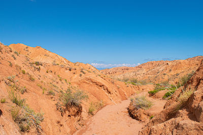 Scenic view of desert against clear blue sky