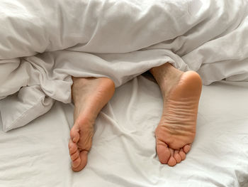 View of male feet, man sleeping at home. middle aged adult man is sleeping at home. cozy bedroom