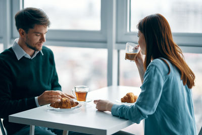 Young woman drinking glass on table