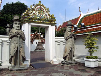 Statue outside temple against sky, wat pho