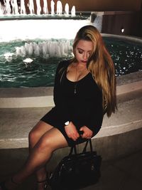 Beautiful young woman sitting in water