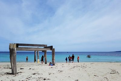 People at beach against sky