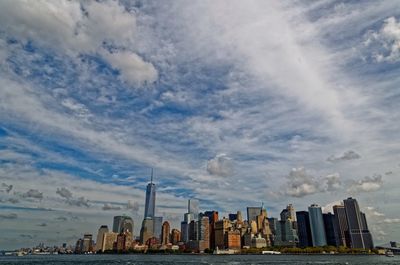 Buildings in city against cloudy sky