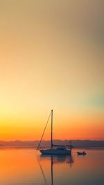 Silhouette sailboats in sea against sky during sunset