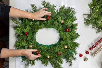 Cropped hands of woman decorating christmas tree