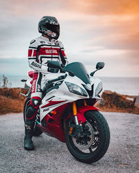 Man riding motorcycle on road against sky