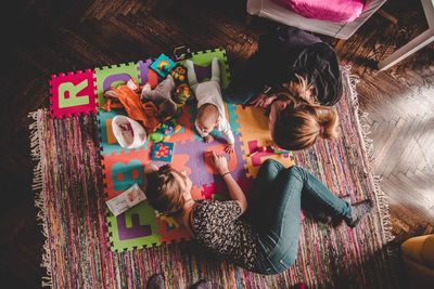 High angle view of girl and toys on floor