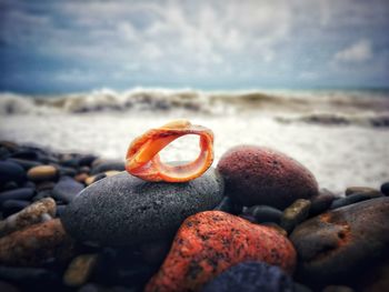 Close-up of stones on beach against sky