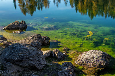 Scenic view of rocks by lake against sky