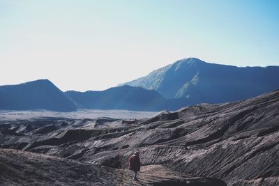 Rear view of man on mountain against sky