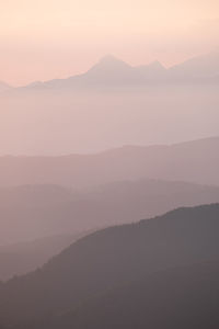 Scenic view of silhouette mountains against sky during sunset