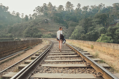 Rear view of man standing on railroad track