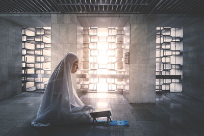 Woman sitting on tiled floor in building