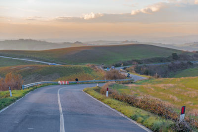 Road amidst agricultural landscape against sky